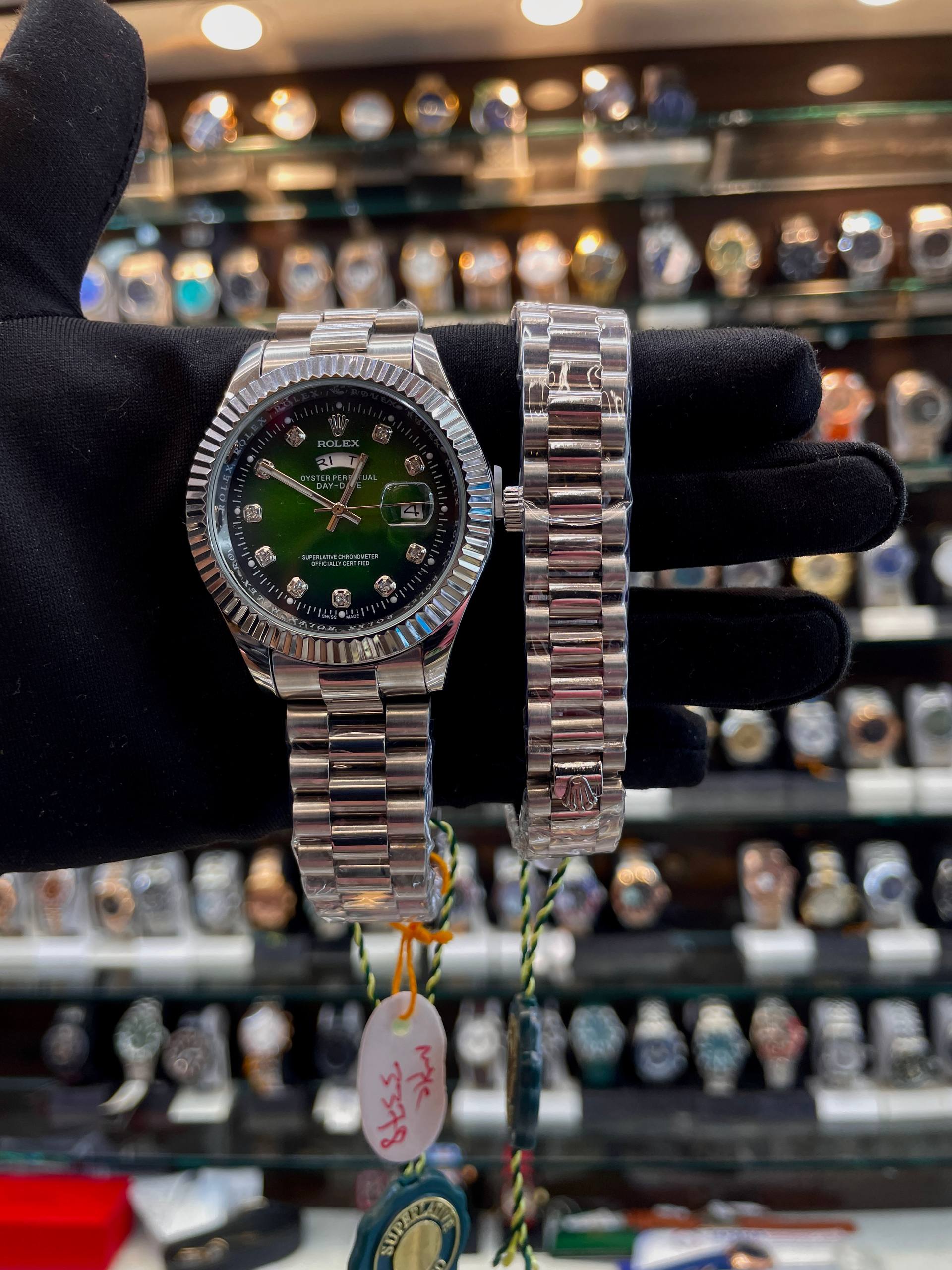 Green dial matching men's and women's watches angled view