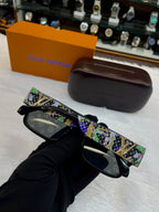 LOUIS VUITTON LV SUNGLASSES FEATURE A BLACK ACETATE FRAME